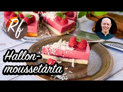 En tårta med hallonmousse samt mandelbotten garnerad med färska hallon, vit choklad samt citronmeliss.>