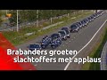 Duizenden mensen staan langs de A2 en applaudisseren als de rouwstoet met MH17-slachtoffers langs...