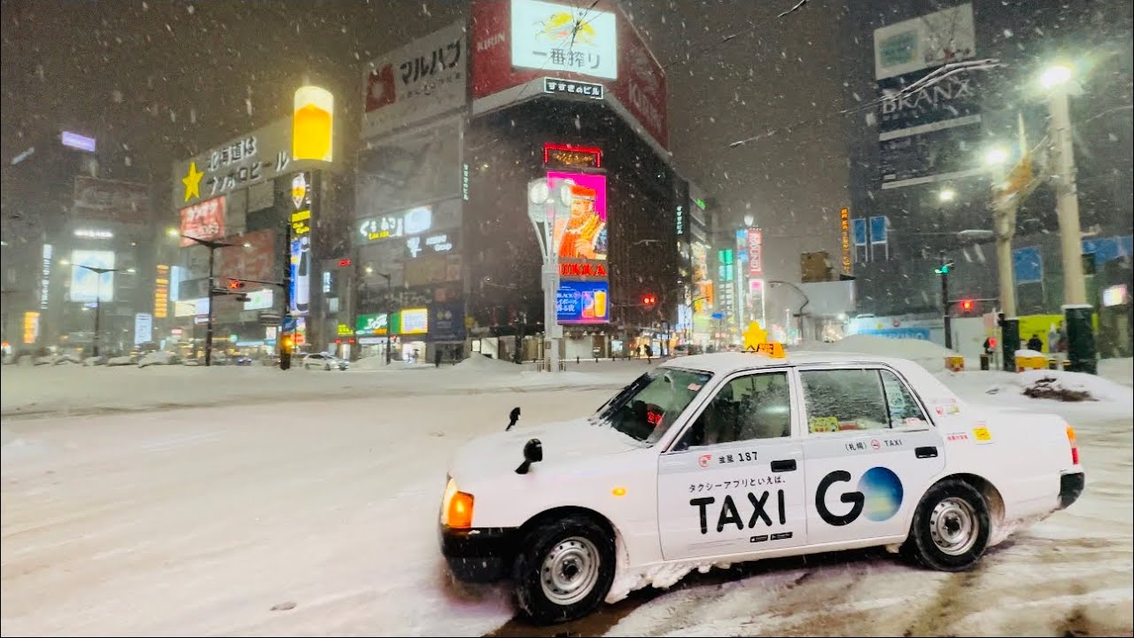 Experience a winter night walking tour through the snow-dusted Susukino District.