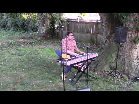 Will Wood kicking his keyboard while chanting the word “Music” at a BBQ