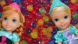 Elsa and Anna toddlers have fun in ORBEEZ ! They slide into colorful water jelly balls!