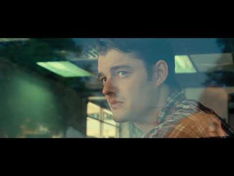 On the Road 2012 trailer still — Sal, Dean, and Marylou in a beat-up car with the highway stretching ahead