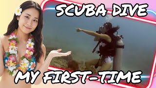 Two scuba divers hover neutrally above a diverse and colorful coral reef structure at a Honolulu dive site.