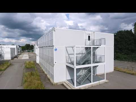 Diese 3-geschossige Containeranlage in Blockaufstellung - bestehend aus hunderten Einzelcontainern, dient als temporäre Unterkunftslösung.