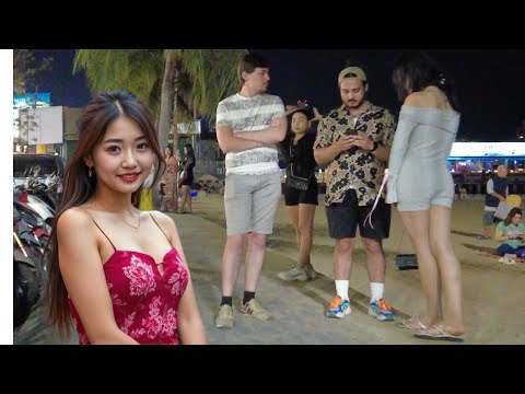 Young Caucasian men talking to beautiful women on Pattaya beach road