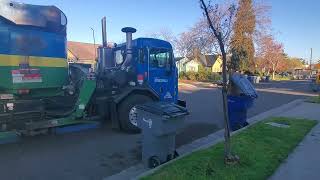 City of Fresno Peterbilt side loader picking up gray garbage can
