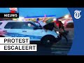 Politieauto rijdt demonstranten omver