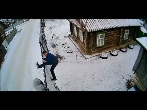 Drunk men struggle with a fence in Yanaule, Russia