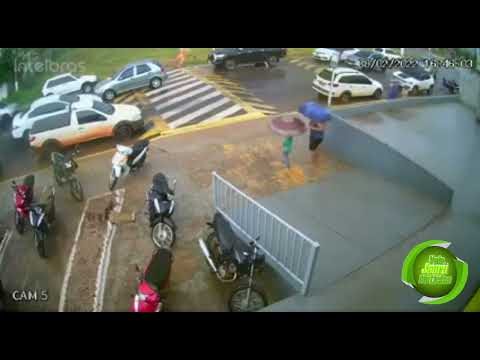 Mãe se revolta com veículo em cima da faixa de pedestre e usa guarda-chuva para mostrar sua indignação.