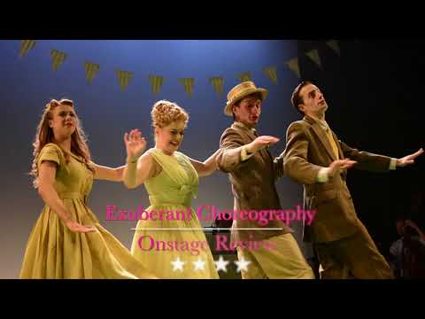 Trailer still from a modern UK tour of Salad Days — a park bench, a push-along piano and dancers bursting into motion