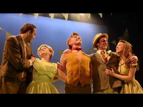 Salad Days trailer frame — a UFO gag lights the stage while the ensemble gapes upward