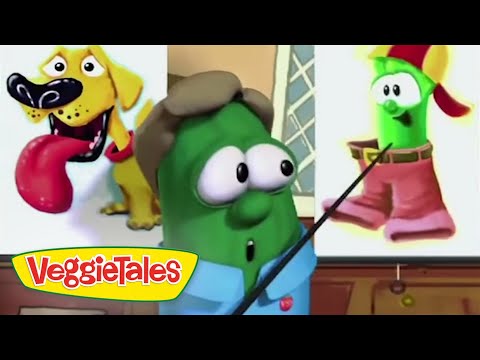 Green VeggieTales character in a classroom presenting with a pointer, screen showing a dog and a clown while the VeggieTales logo appears in the corner.