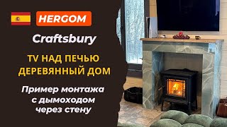 Чугунная печь Hergom Craftsbury. Телевизор над камином в деревянном доме. Дымоход через стену
