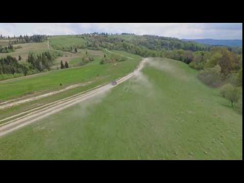 Suv Convoy Traveling Through the Mountains of the Carpathians. the Camera Flies Over the Trees and