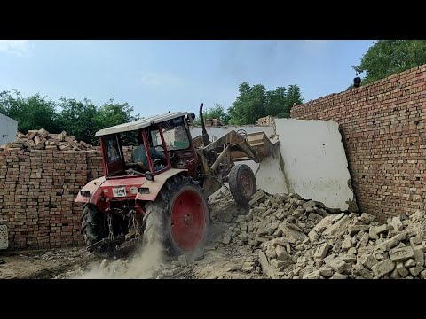 Tractor is tearing down the walls with a hydraulic loader