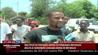 Multitud de personas impide autoridades impongan multa a camionero que cargaba arena de río Nigua