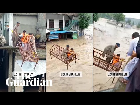Pakistan flood victims rescued on bed frame pulled over raging waters