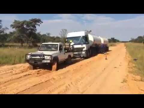 Landcruiser pulls out truck stuck in mud