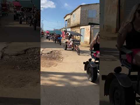 Caravana de bicitaxis con turistas por calles de Cuba en Remedios Villa Clara.