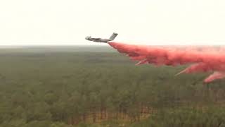French military aircraft deploys fire retardant over forest wildfire