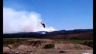 preview picture of video 'SDGE's sky crane 7AC taking off as large wildfire burns in the background'