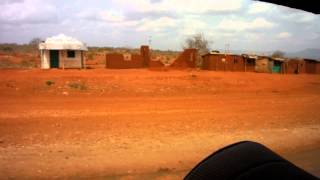 Rote Erde und Massai Häuser an der Straße A109 von Mombasa Richtung Tsavo Ost National Park Kenia