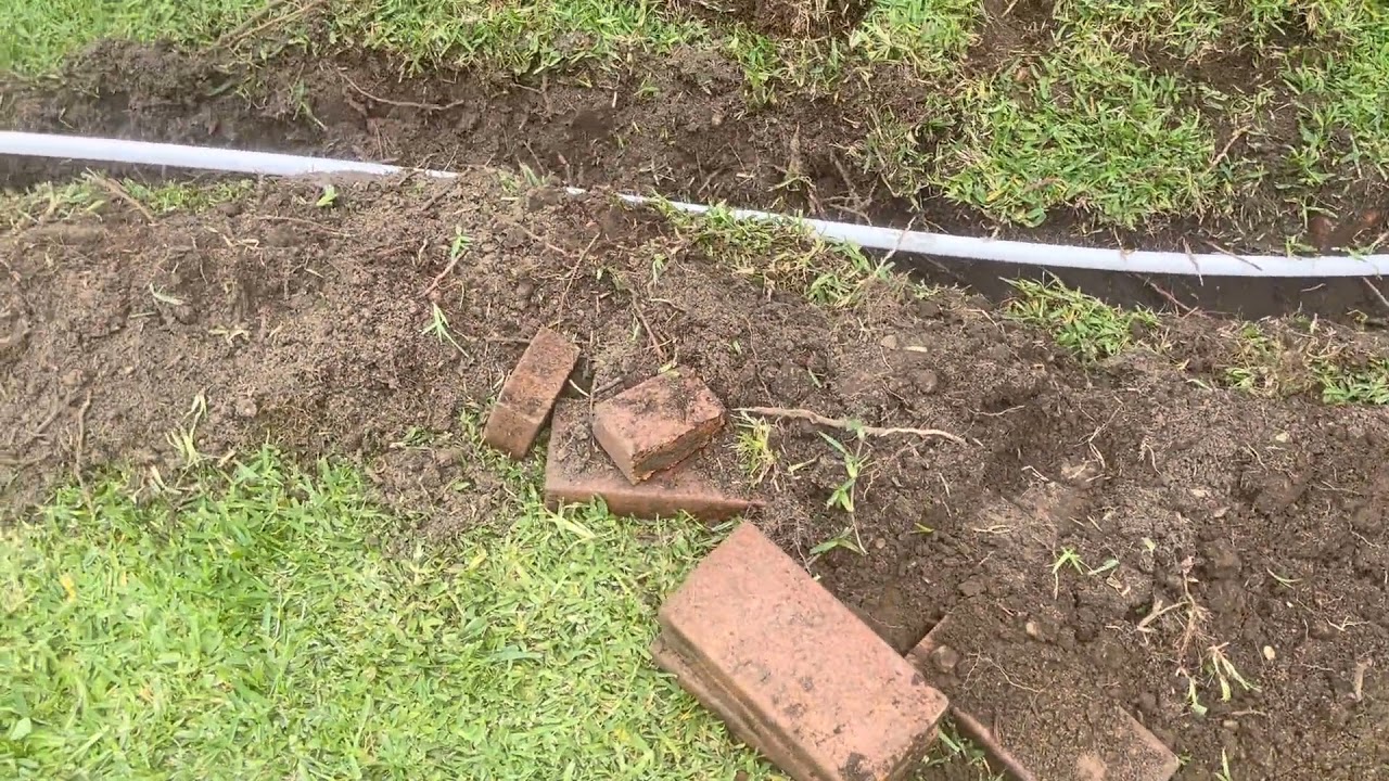 Jason from SECURE A COM digging trench and installing P20 conduit for NBN FTTC lead-in cable in Abbotsford Sydney — navigating tree roots and old buried brickwork
