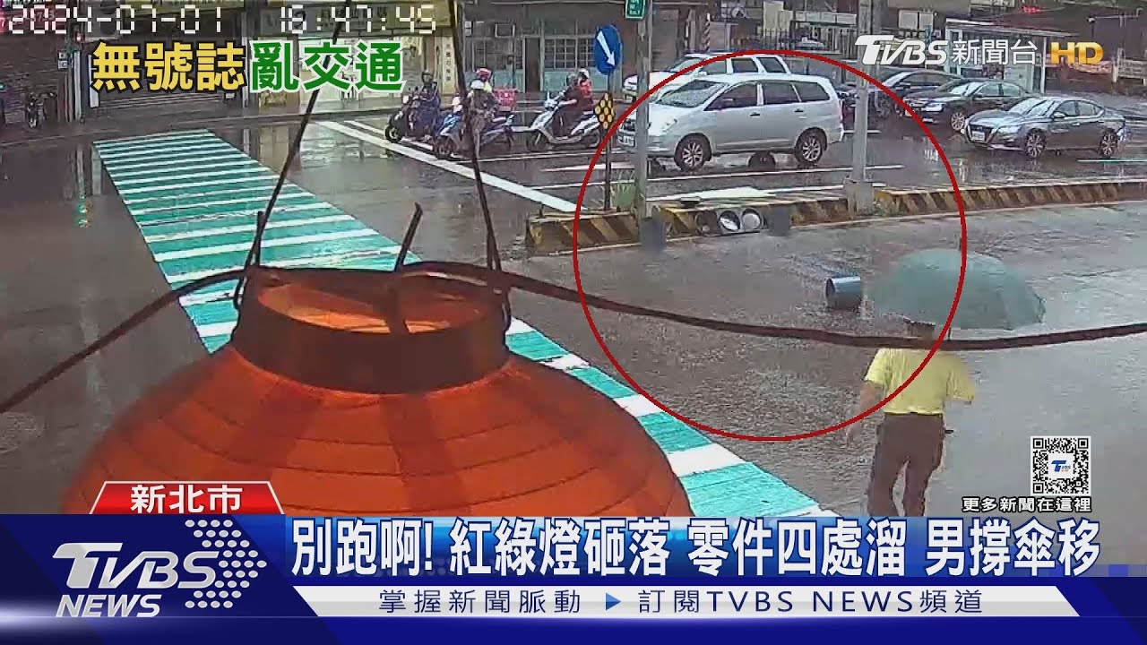 別跑啊！紅綠燈砸落　零件四處溜　男撐傘移