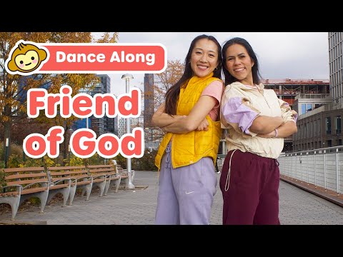 Two women stand with arms crossed on a urban walkway, a bold 'Dance Along' banner and 'Friend of God' text over the image, suggesting a video thumbnail.