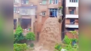Flood water gushes through residential building in SW China creating a waterfall