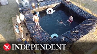 Farmers create swimming pool out of hay bales duri