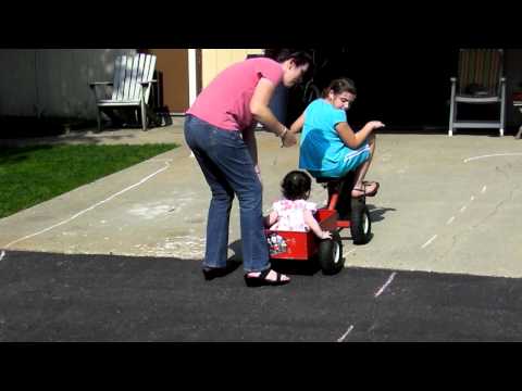 KATELYN GIVING EVA A RIDE IN THE TRICYCLE TRAILER   MAY 28, 2011