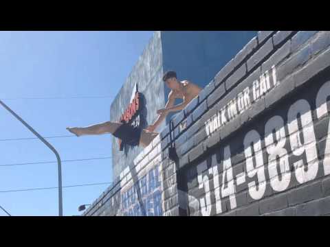 Crazy stunt off roof. Boxing coach does dragon flag off gym.