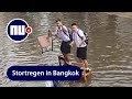 Thaise scholieren steken op stoelen ondergelopen binnenplaats over | NU.nl