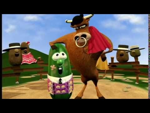 Cartoon bull wearing a red cape stands beside a cheerful green vegetable character in a field scene with spectators.