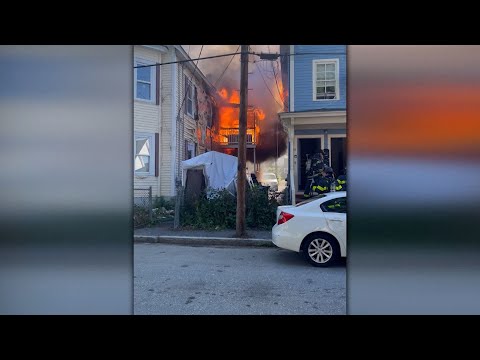 Heavy flames tear through neighboring multi-family homes in Lowell