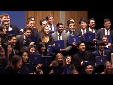 Still from video featuring graduates posing with certificates.