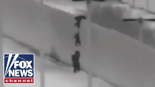 Migrant children seen being dropped over US border wall