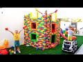 Vlad et Niki jouent avec des blocs de jouets colorés et construisent une maison à trois niveaux