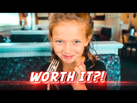 Smiling young girl holding a fork in a restaurant, with bold 'WORTH IT?!' text overlay.