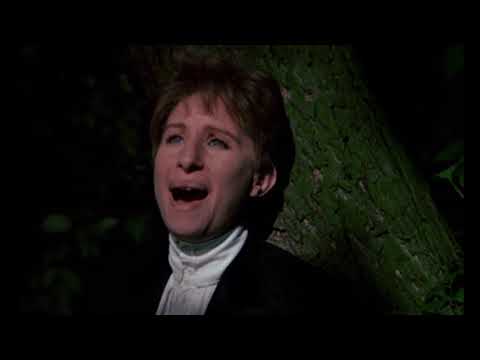 Trailer montage still of Yentl in men’s attire crossing a bridge at dusk
