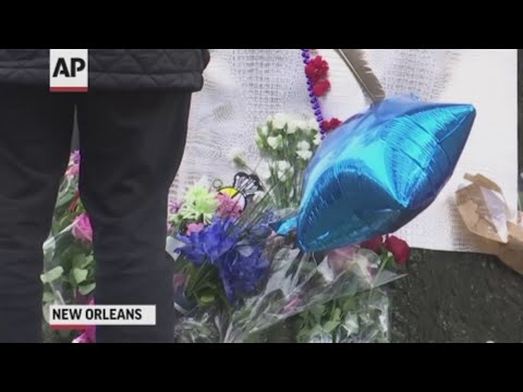 Mourners placed bouquets and Mardi Gras beads near the bike lane in New Orleans where two cyclists were killed and seven people were injured over the weekend. (March 4)