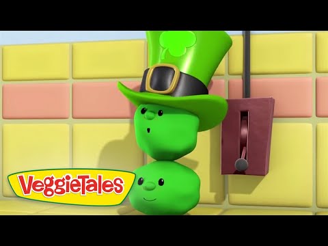 Three green vegetables stacked as a figure wearing a tall leprechaun hat with a clover, beside a red wall switch.
