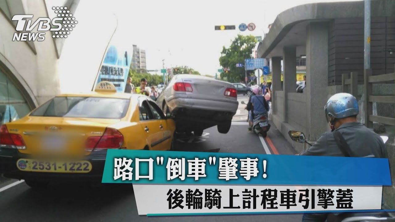 路口倒車肇事！　後輪騎上計程車引擎蓋