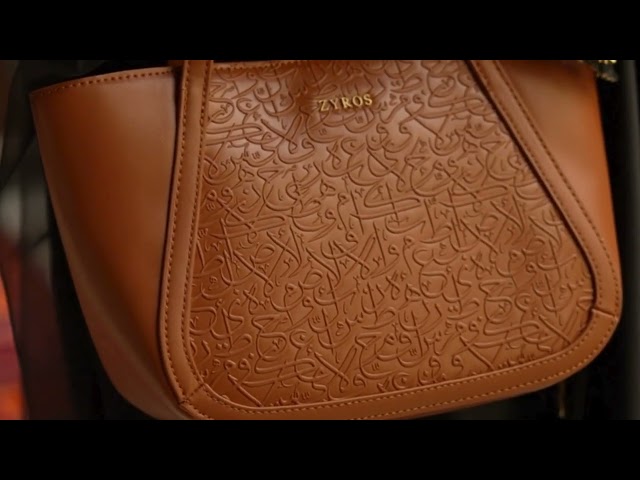 شنطة نسائية بتصميم كلاسيك بلون بني.