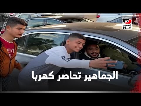 الجماهير تلتف حول سيارة كهرباء لالتقاط الصور.. وأحد المشجعين : هاجيبلك شورت وفانلة وألاعبك أساسي