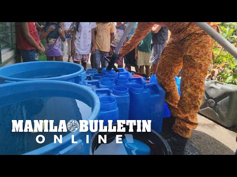 Firefighter supplies water to the families affected by danger zone surrounding Mayon