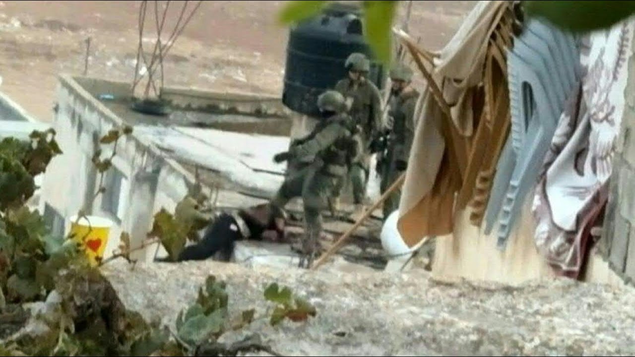 Soldados israelenses flagrados atirando corpo de palestino de um telhado na Cisjordândia | AFP