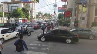Pedestrians walk over a front car hood that stop in the pedestrian lane