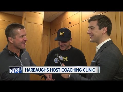 Jim and John Harbaugh jab at each other in conversation with Brad Galli at Michigan Coaching Clinic